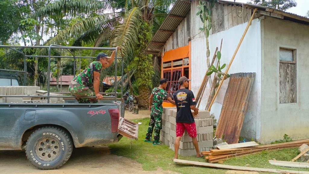 Anggota Satgas TMMD ke-128 Bersama Warga Gotong Royong Turunkan Batako untuk RTLH