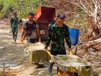 Anggota Satgas TMMD Silih Berganti Mengangkut Adonan Semen Guna Membuat Rabat Beton