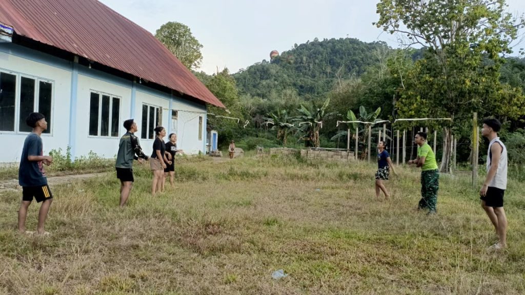 Kebersamaan Anggota Satgas dan Remaja Bermain Voli Setelah Melaksanakan Kegiatan